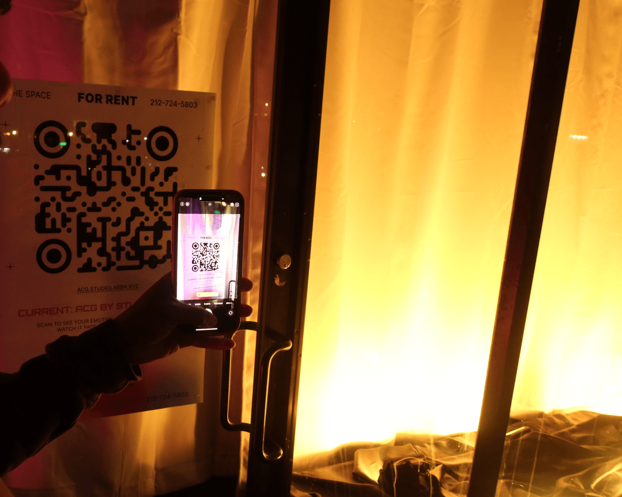 A visitor scans the storefront prompt beside a window filled with yellow light